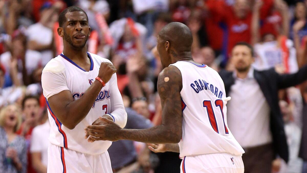 Clippers teammates Chris Paul, left, and Jamal Crawford celebrate during the final minute of the team's Game 4 win over the Oklahoma City Thunder on Sunday.
