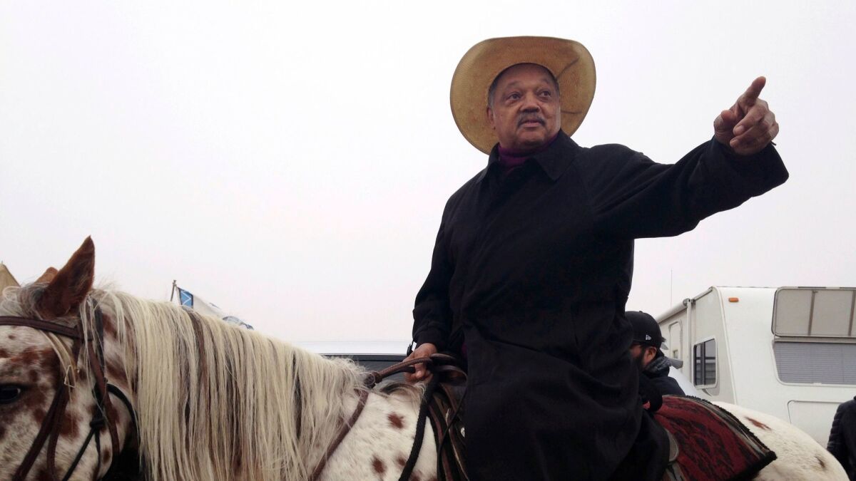 Civil rights activist Jesse Jackson sits atop a horse Wednesday, Oct. 26, 2016, while visiting the protest camp against the Dakota Access oil pipeline outside Cannon Ball, N.D.