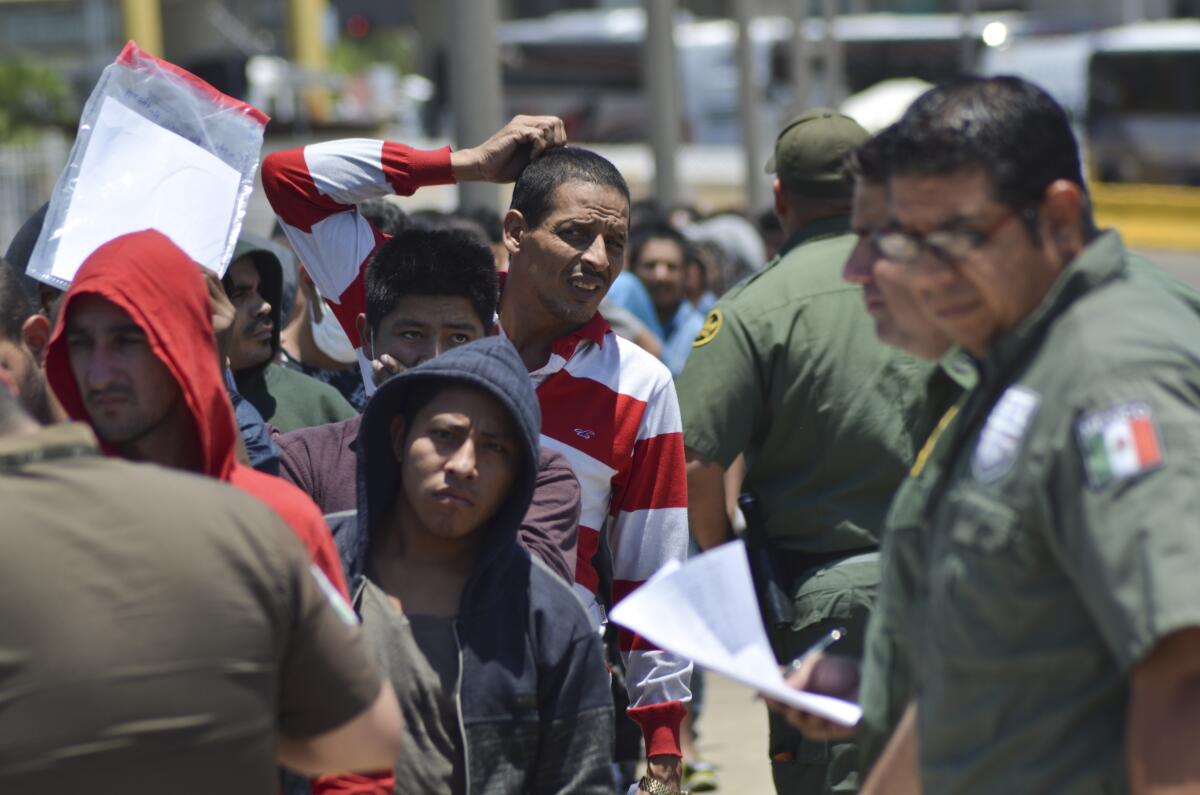 Agentes mexicanos verifican una lista de migrantes devueltos por la Patrulla Fronteriza a México en Nuevo Laredo, estado de Tamaulipas, el jueves 25 de julio de 2019. (AP Foto/Salvador González)