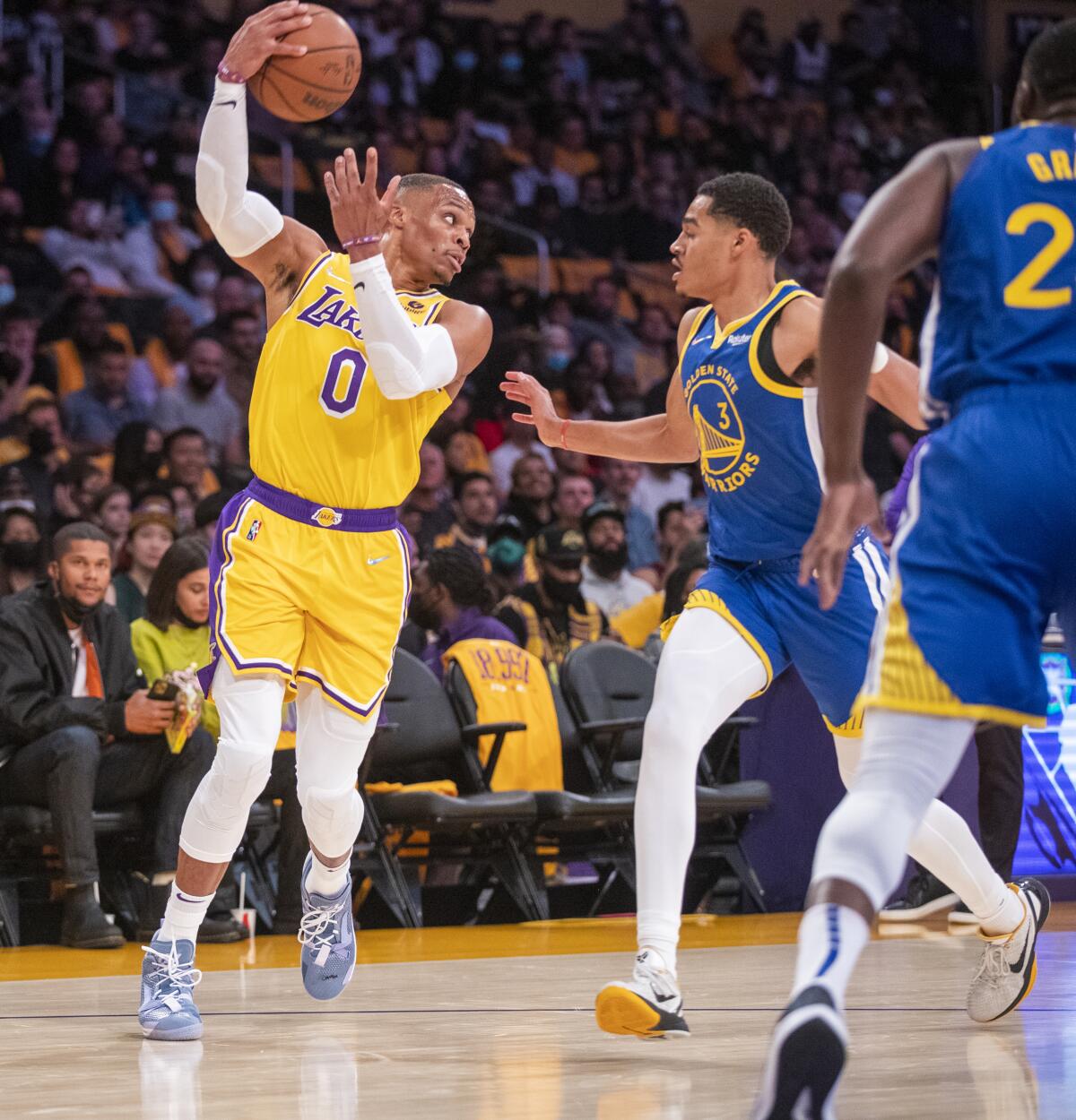 Lakers guard Russell Westbrook passes the ball over Warriors guard Jordan Poole.