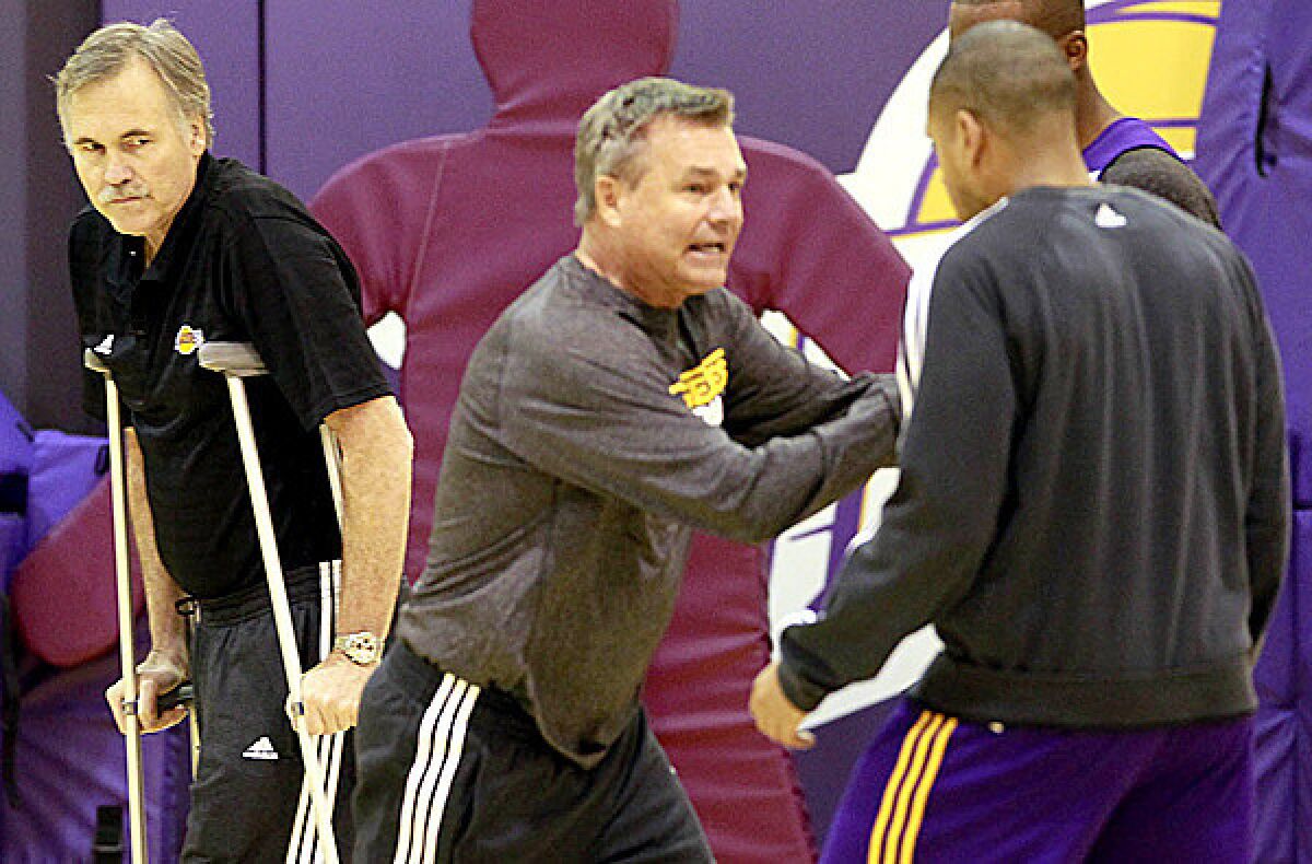 A then-hobbled Lakers Caoch Mike D'Antoni, left, watches his brother, assistan Dan D'Antoni instruct during a practice last summer.