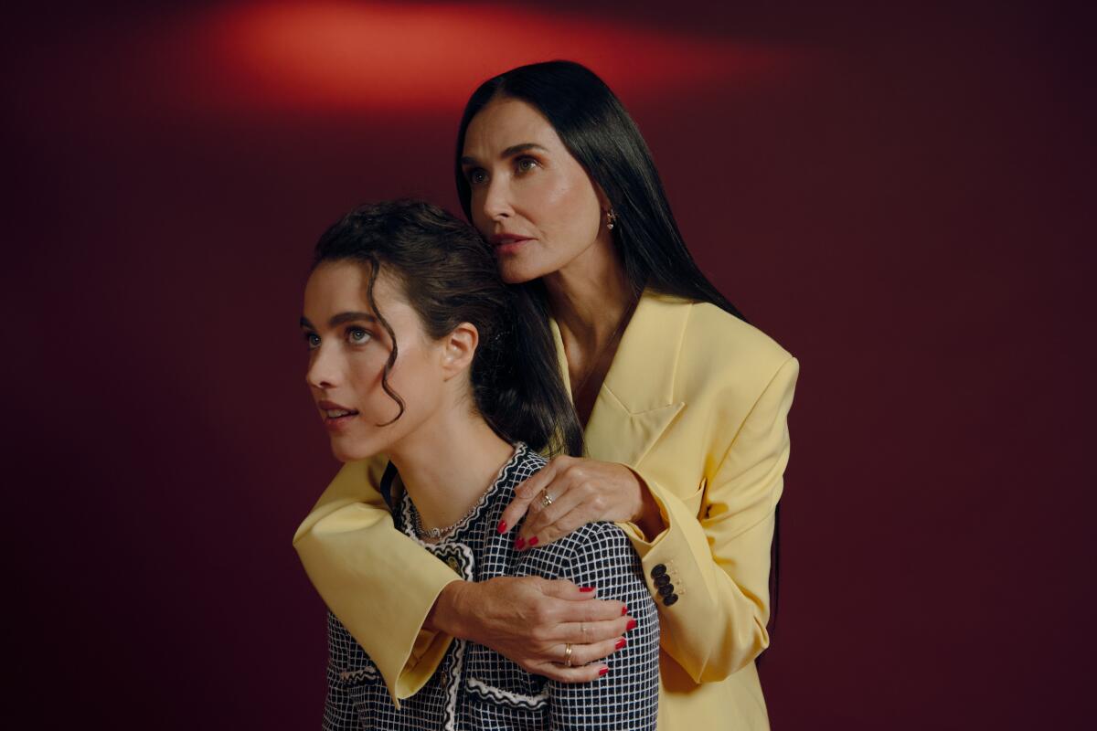 Demi Moore wraps an arm around Margaret Qualley for a portrait.