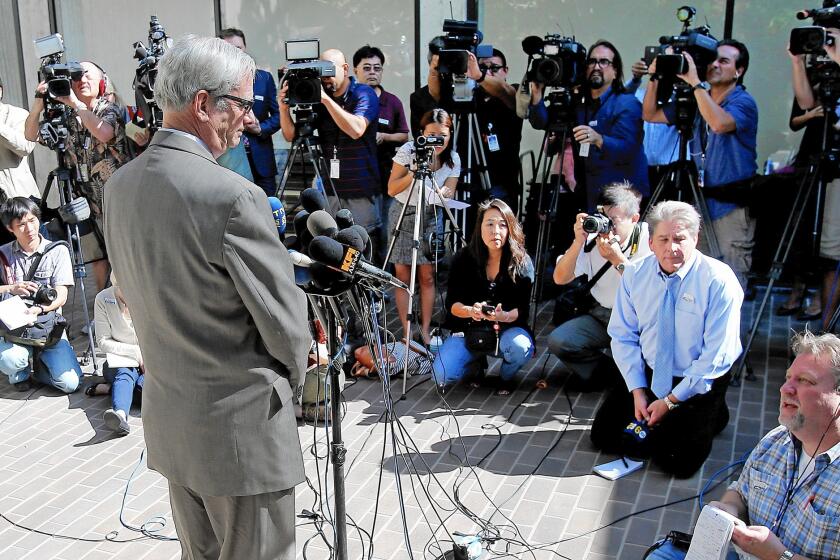 Dr. Robert Kim-Farley, left, director of Communicable Disease Control and Prevention for the Los Angeles County Department of Public Health, answers reporters' questions regarding Ebola at a news conference.