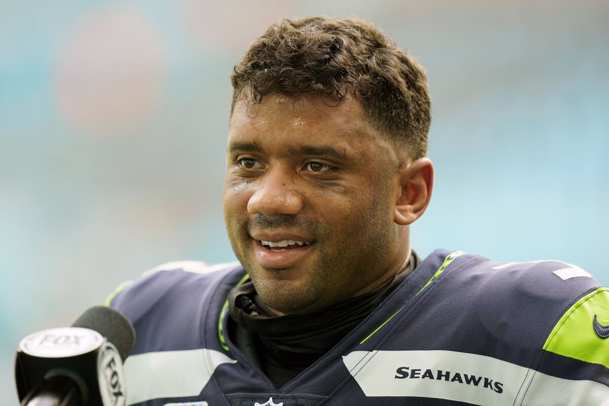 Seattle Seahawks quarterback Russell Wilson (3) talks at the end of an NFL football game, Sunday, Oct. 4, 2020, in Miami Gardens, Fla. Seattle's star quarterback Russell Wilson and Kansas City's standout tight end Travis Kelce are among the 32 finalists for the Walter Payton NFL Man of the Year award. (AP Photo/Wilfredo Lee)