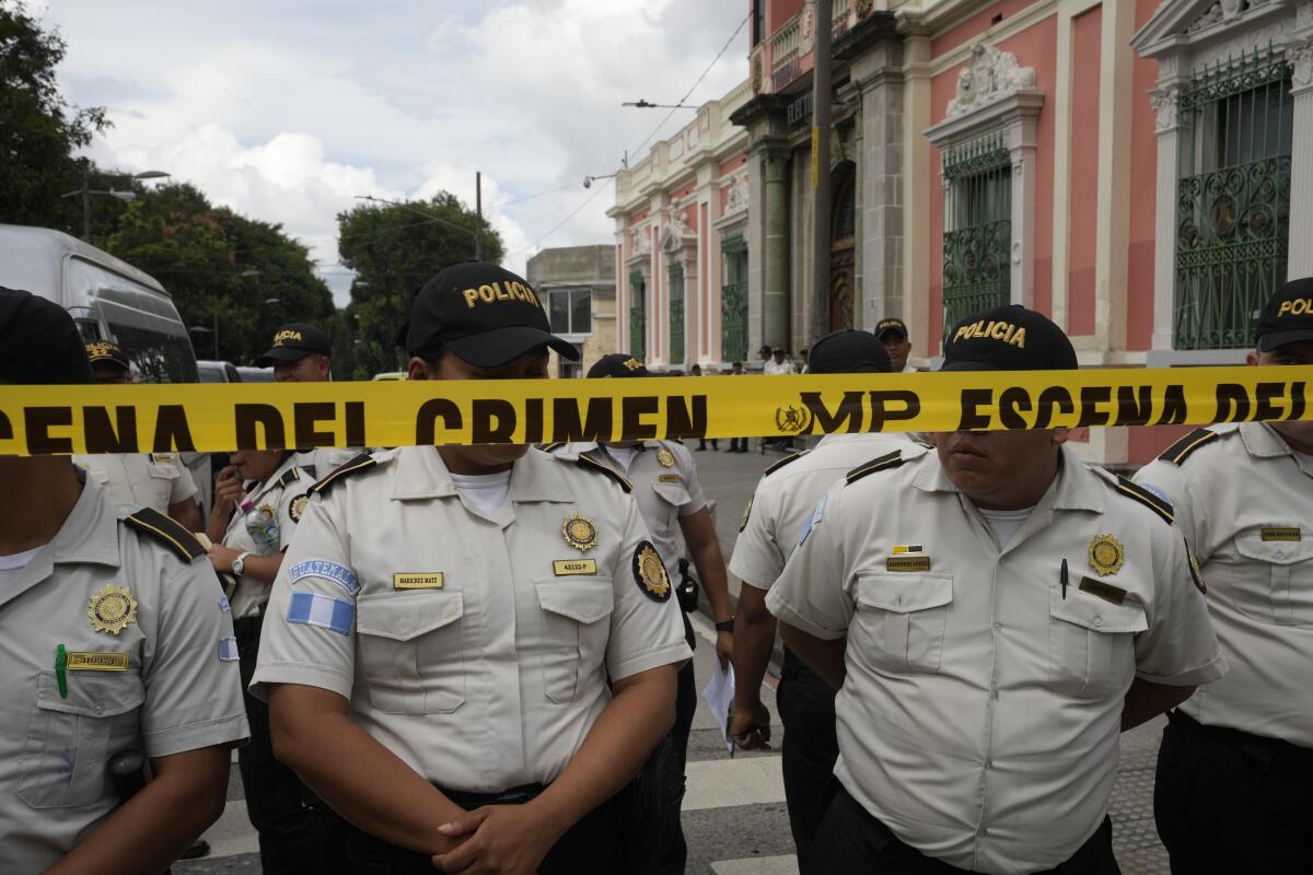 La policía hace guardia mientras agentes de la Fiscalía General allanan el Tribunal Supremo Electoral en la Ciudad de Guatemala, el viernes 29 de septiembre de 2023. (AP Foto/Moisés Castillo)