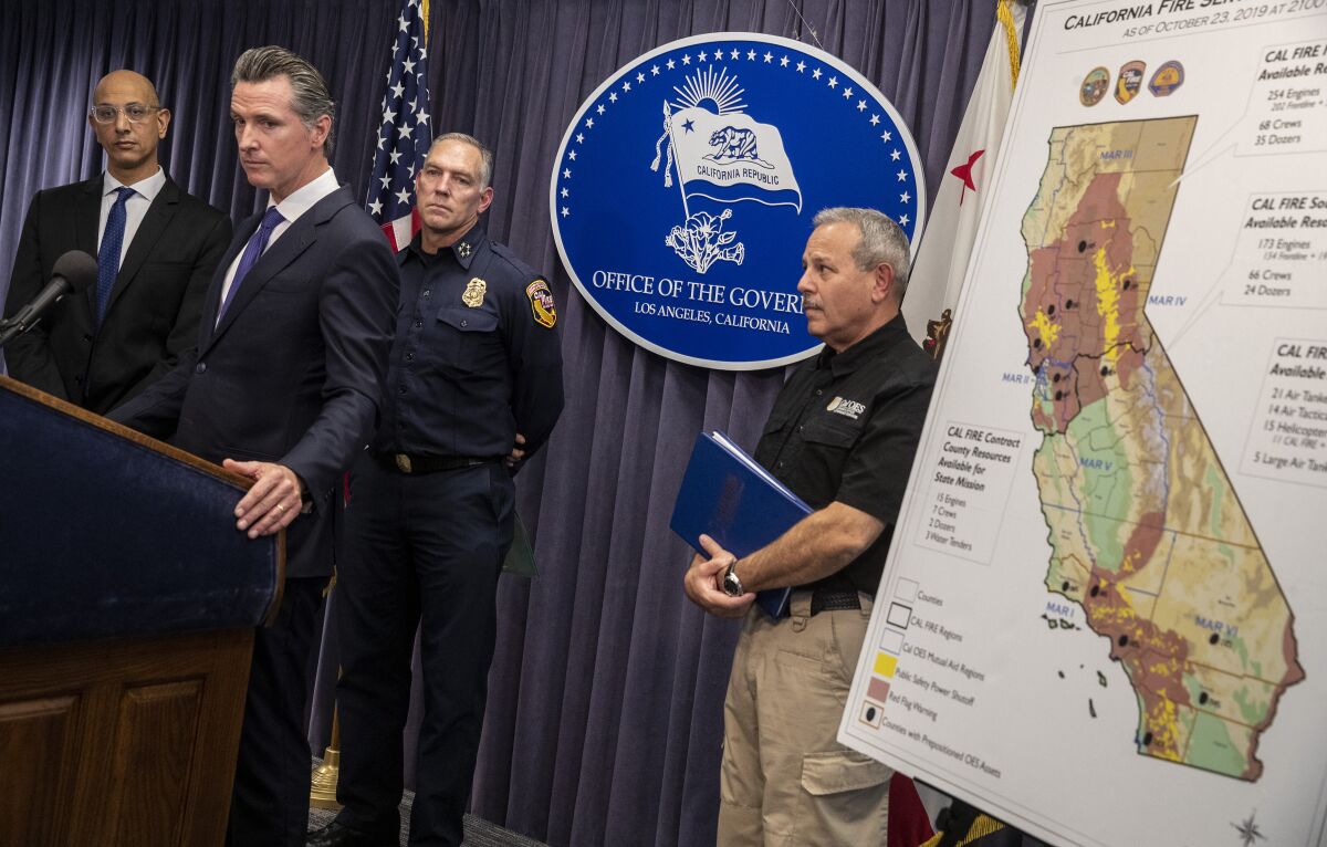 California Gov. Gavin Newsom, at lectern, holds a news conference with California Health and Human Services Agency Secretary Mark Ghaly, left, California Department of Forestry and Fire Protection Director Thom Porter, second from right, and California Governor's Office of Emergency Services Director Mark Ghilarducci.