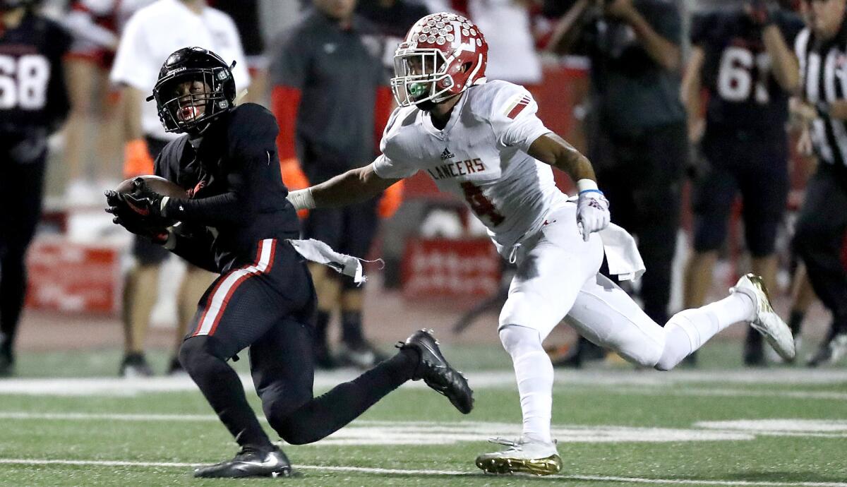 Centennial receiver Gary Bryant makes a catch against Orange Lutheran defensive back KJ Trujillo on Friday night. Bryant took the catch the distance as No. 2-seeded Centennial pulled away for a 35-7 victory.