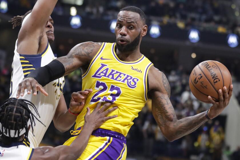 Los Angeles Lakers forward LeBron James (23) makes a pass as he's defended by Indiana Pacers guard Aaron Holiday (3) and center Myles Turner (33) during the first half of an NBA basketball game in Indianapolis, Tuesday, Dec. 17, 2019. (AP Photo/Michael Conroy)