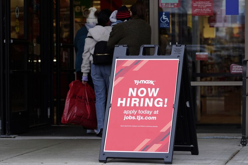 Hiring sign is displayed outside of a retail store in Vernon Hills, Ill., Saturday, Nov. 13, 2021. The number of Americans applying for unemployment benefits plummeted last week to the lowest level in more than half a century, another sign that the U.S. job market is rebounding rapidly from last year’s coronavirus recession. (AP Photo/Nam Y. Huh)