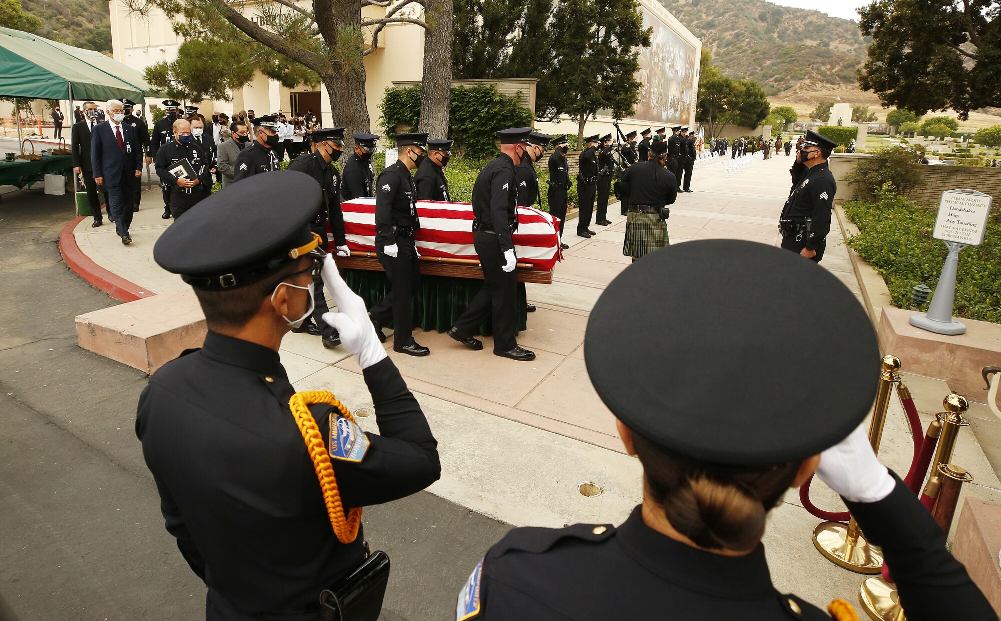 LAPD Officer Valentin Martinez's flag-covered coffin is carried into Forest Lawn Hollywood Hills.