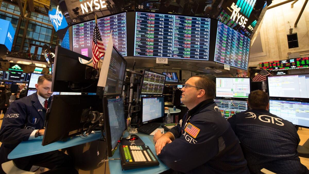 Traders work on the floor at the closing bell Friday at the New York Stock Exchange.