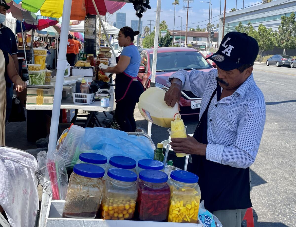 Un comerciante prepara una minuta a clientes que llegan por productos nostálgicos al corredor salvadoreño.