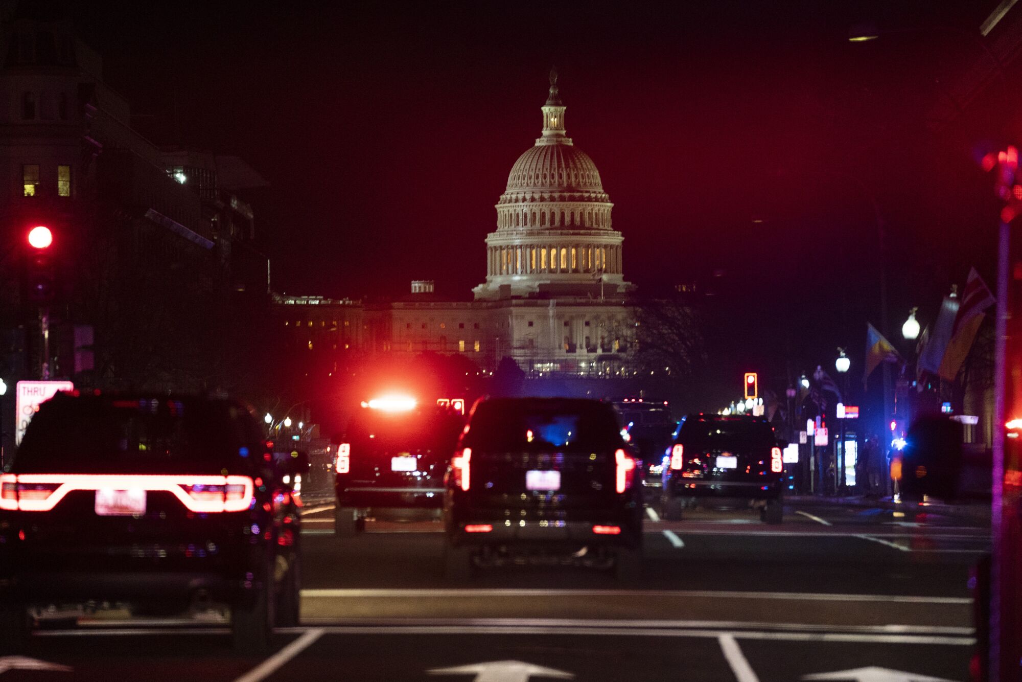 A motorcade with President Biden drives toward the U.S. Capitol building.
