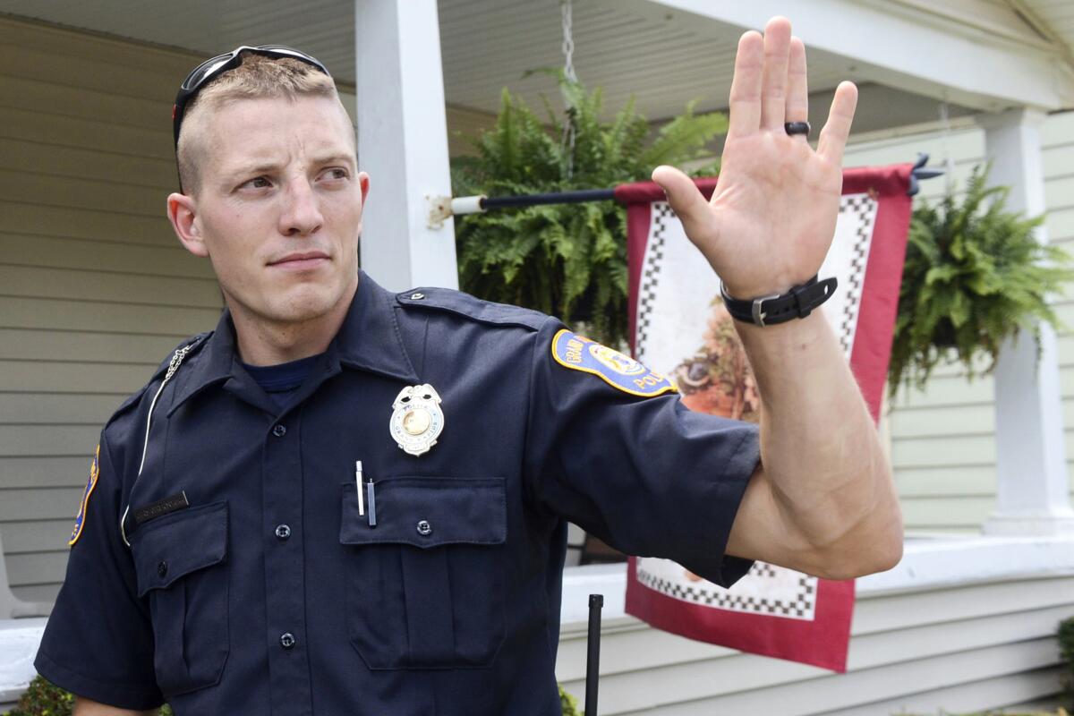 FILE - Grand Rapids Police Officer Christopher Schurr stops to talk with a resident, on Aug. 12, 2015, in Grand Rapids, Mich. Schurr, charged with second-degree murder in the death of Patrick Lyoya, a Black man who was shot in the back of the head in April, has been fired, officials said Wednesday, June 15, 2022. (Emily Rose Bennett/The Grand Rapids Press via AP, File)