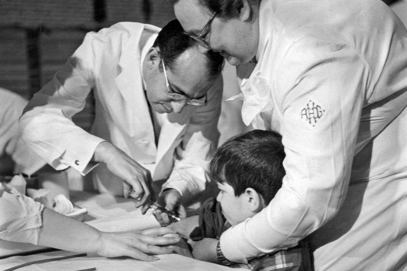 Dr Jonas Salk gives an eight year old boy a trial polio vaccine at the Frick Elementary School, Pittsburgh, Pennsylvania, February, 1954. (Photo by Underwood Archives/Getty Images)