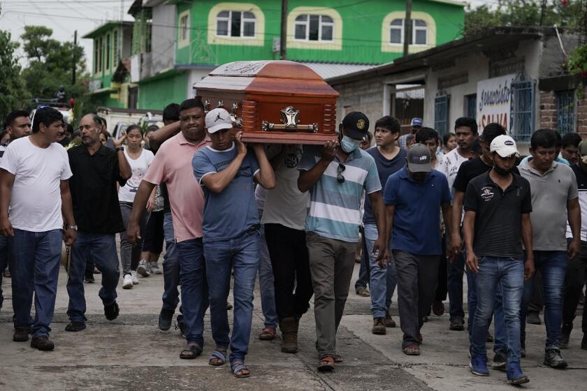 Residents carry the coffin of Wilmer Rojas the day after he was killed in a mass shooting in San Miguel Totolapan, Mexico, Thursday, Oct. 6, 2022. A drug gang bursted into the town hall and shot to death 20 people, including a mayor and his father, officials said Thursday. (AP Photo/Eduardo Verdugo)