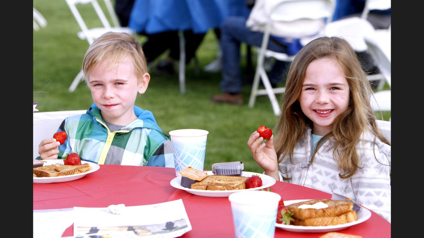 Twins Max and Maddie Korn, 6, enjoy their french toast breakfast at the 44th annual Memorial Day Weekend Fiesta Days Breakfast at Memorial Park in La Cañada Flintridge on Saturday, May 27, 2017. The event, sponsored by the Kiwanis Club of La Cañada La Crescenta-AM, also had a vintage car show and music by the band Misplaced Priorities.