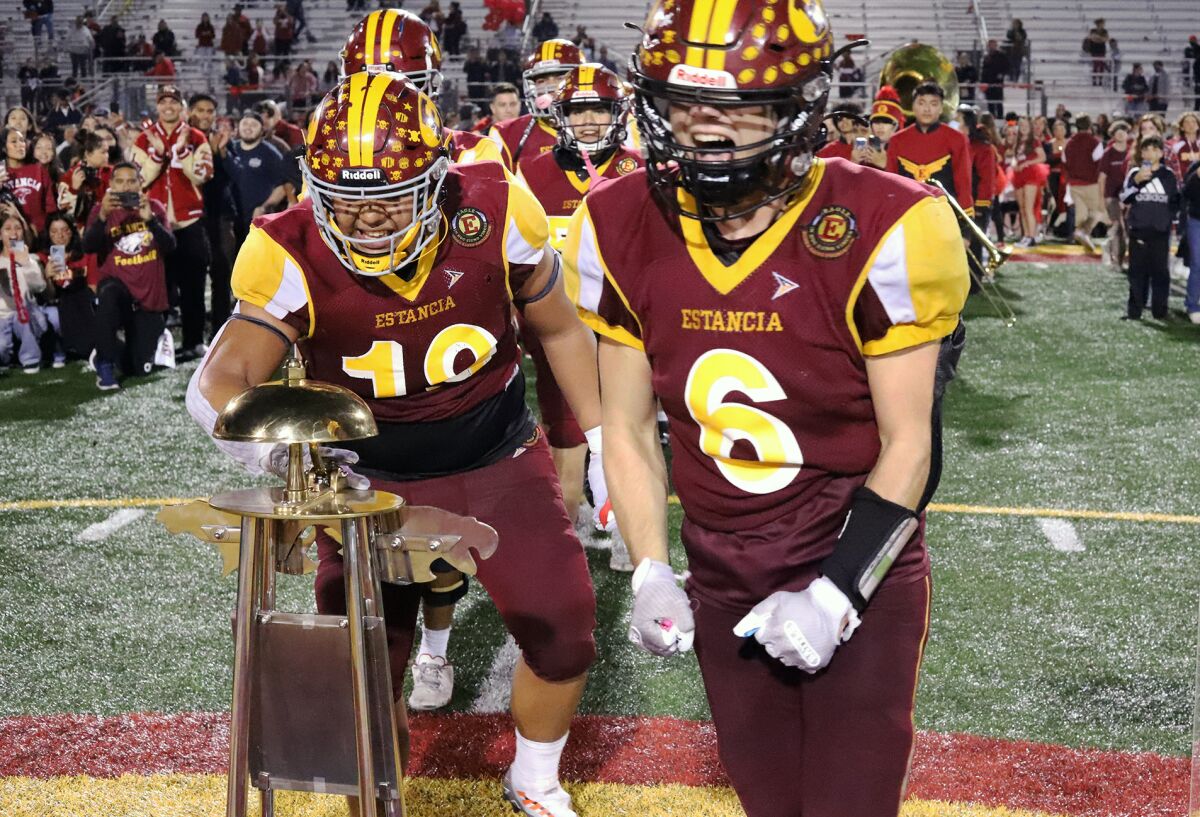 Estancia's Oswaldo Sanchez (19) and Noah Aires (6) celebrate with their team as they ring the bell after beating Costa Mesa.