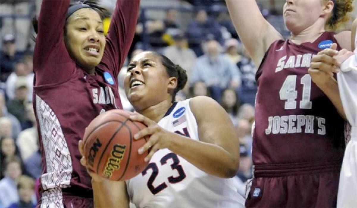 Connecticut's Keleena Mosqueda-Lewis splits the defense of St. Joseph's forward Ashley Robinson, left, and Sarah Fairbanks, right, during the first half of the Huskies' 91-52 win.