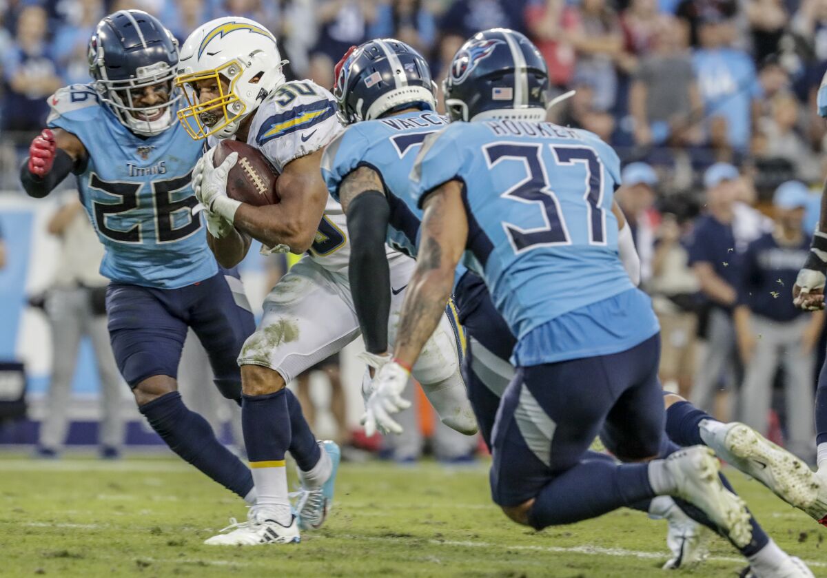 Chargers running back Austin Ekeler (30) avoids tacklers on a run near the goal line late  against the Tennessee Titans on Sunday at Nashville, Tenn.