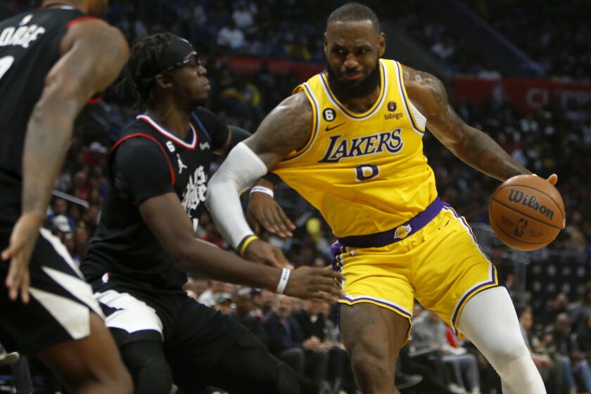 LOS ANGELES, CALIF. - NOV. 9, 2022. Lakers forward LeBron James tries to work the ball inside against Clippers defenders Paul George and. Reggie Jackson in the fourth quarter at Crypto.com Arena in Los Angeles on Wednesday night, Nov. 9, 2022. (Luis Sinco / Los Angeles Times)