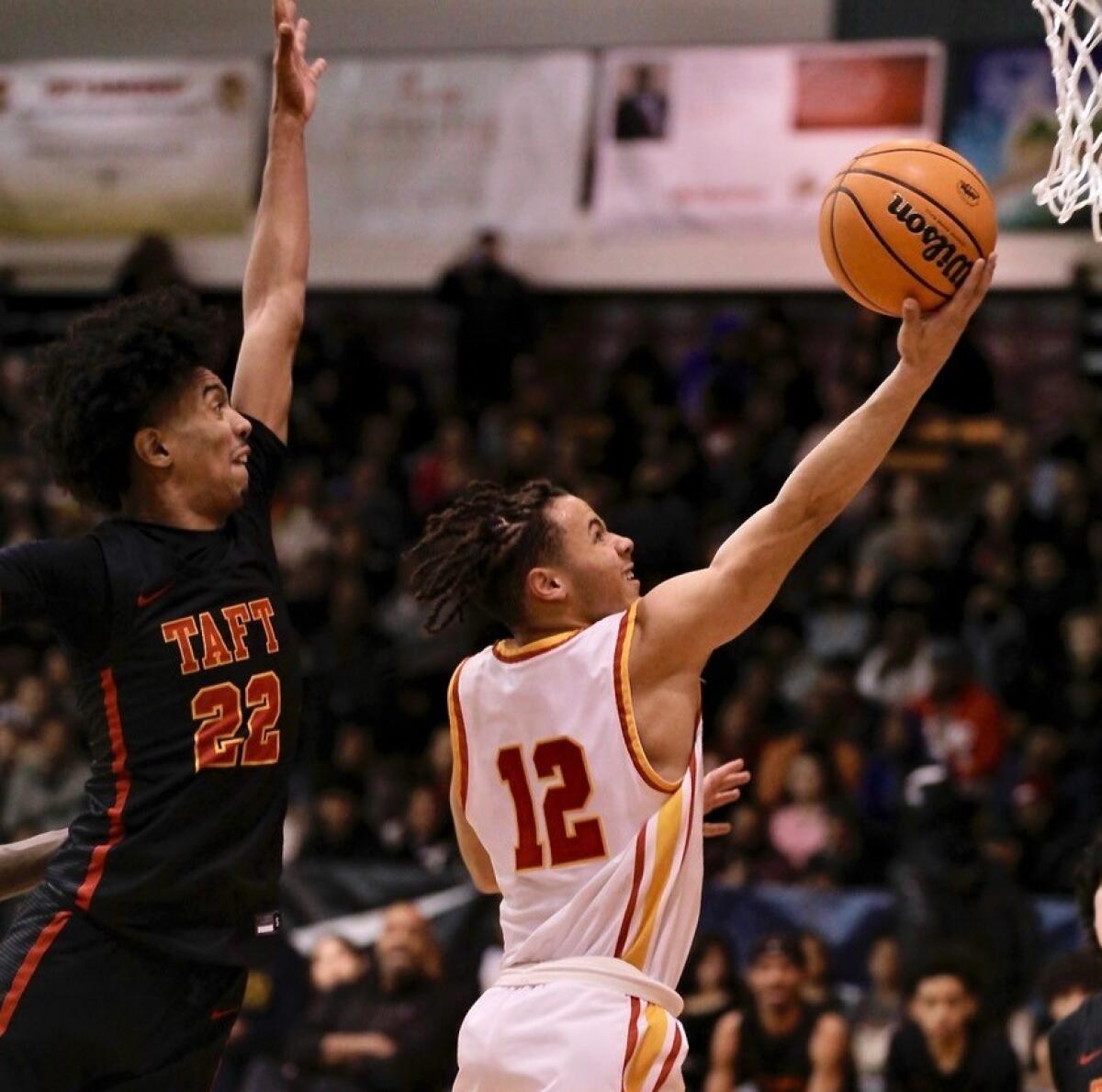 Fairfax guard David Mack drives for a layup around Taft guard Derrick Hill in the City Section Open Division final.