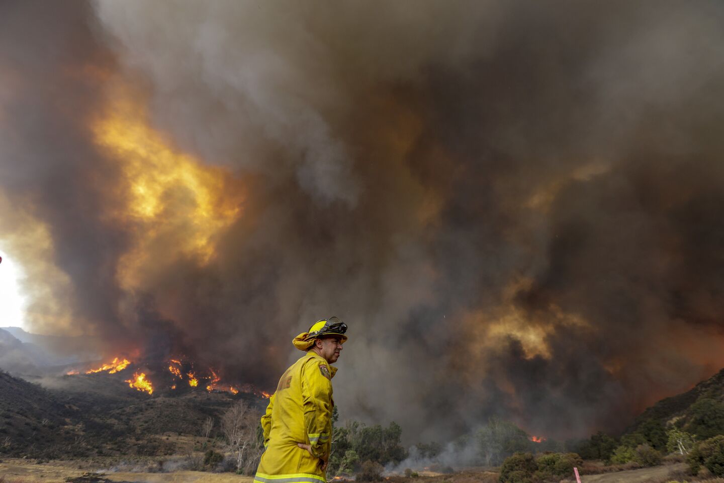 Cal Fire's Mario Gonzalez keeps an eye on the Holy fire raging near homes in Leach Canyon.