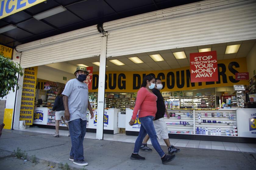 People walk past Drug Discounters on Avenida de la Amistad in Tijuana on June 11th, 2020. Some residents of Chula Vista and San Ysidro are struggling with accessing their medications. They usually cross the border to buy medicine at a cheaper price to treat various illnesses, including asthma, diabetes, depression, mental health disorders, etc.