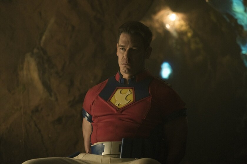 A man in a superhero suit standing in a cave