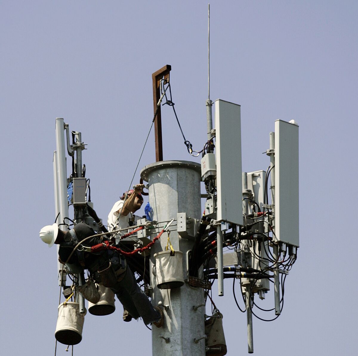 Workers are seen at the construction of a cellular telephone antenna tower.