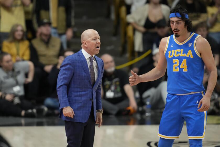 UCLA head coach Mick Cronin confers with guard Jaime Jaquez Jr. (24) in the first half of an NCAA college basketball game Sunday, Feb. 26, 2023, in Denver. (AP Photo/David Zalubowski)