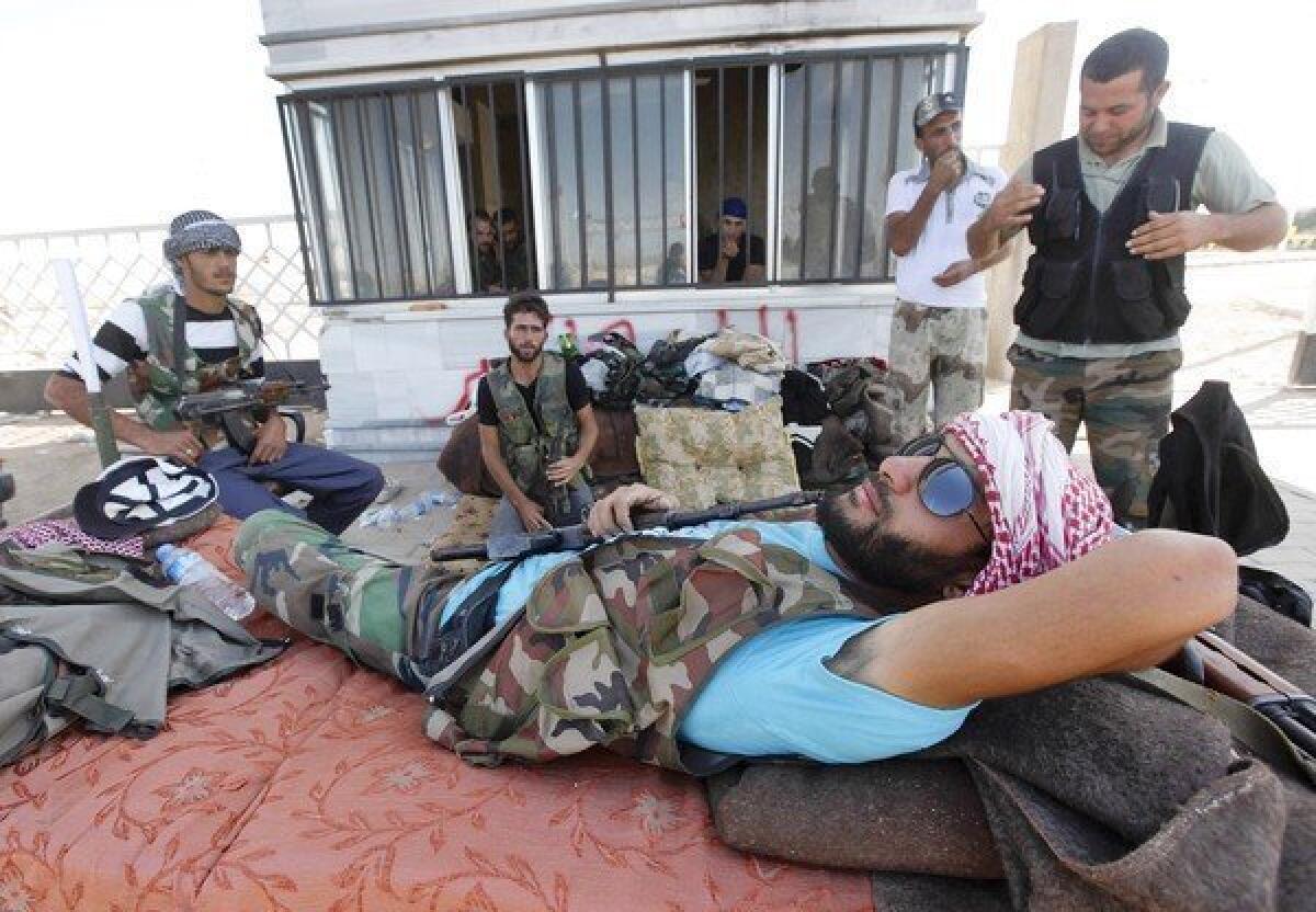 Free Syrian Army fighters rest at a Syrian-Turkish border crossing captured by the rebels last week.