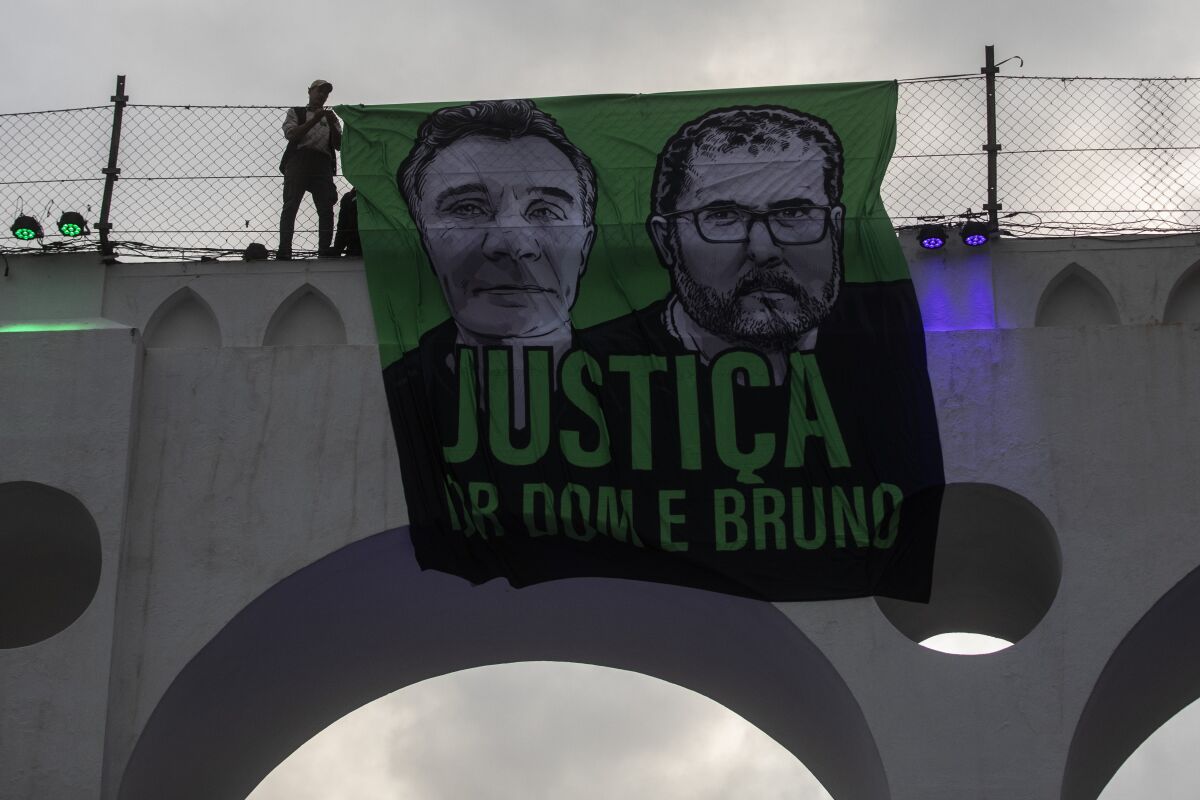 A sign that reads in Portuguese "Justice for Dom and Bruno" and with images of the British journalist Dom Phillips, on the left, and the indigenous specialist Bruno Pereira is displayed on the Arcos da Lapa aqueduct during a protest by environmental groups to ask for justice for their deaths, in Rio de Janeiro, Brazil, Sunday, June 26, 2022. (AP Photo/Bruna Prado)