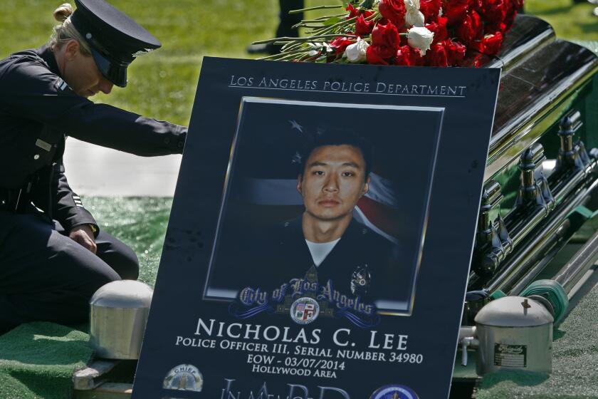 LAPD Officer Leila Ryan, who was a police academy classmate of Officer Nicholas Lee's, pays her respects during a graveside service in March 2014. Nearly a year later, CHP investigators arrested truck driver Roberto Maldonado on suspicion of vehicular manslaughter in Lee's death.