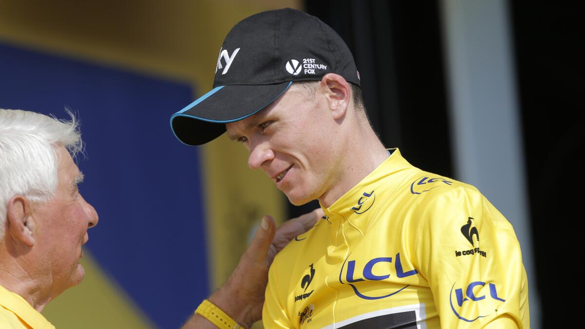 Chris Froome, wearing the race leader's yellow jersey, speaks to former rider Raymond Poulidor after Stage 14 of the Tour de France on Saturday.