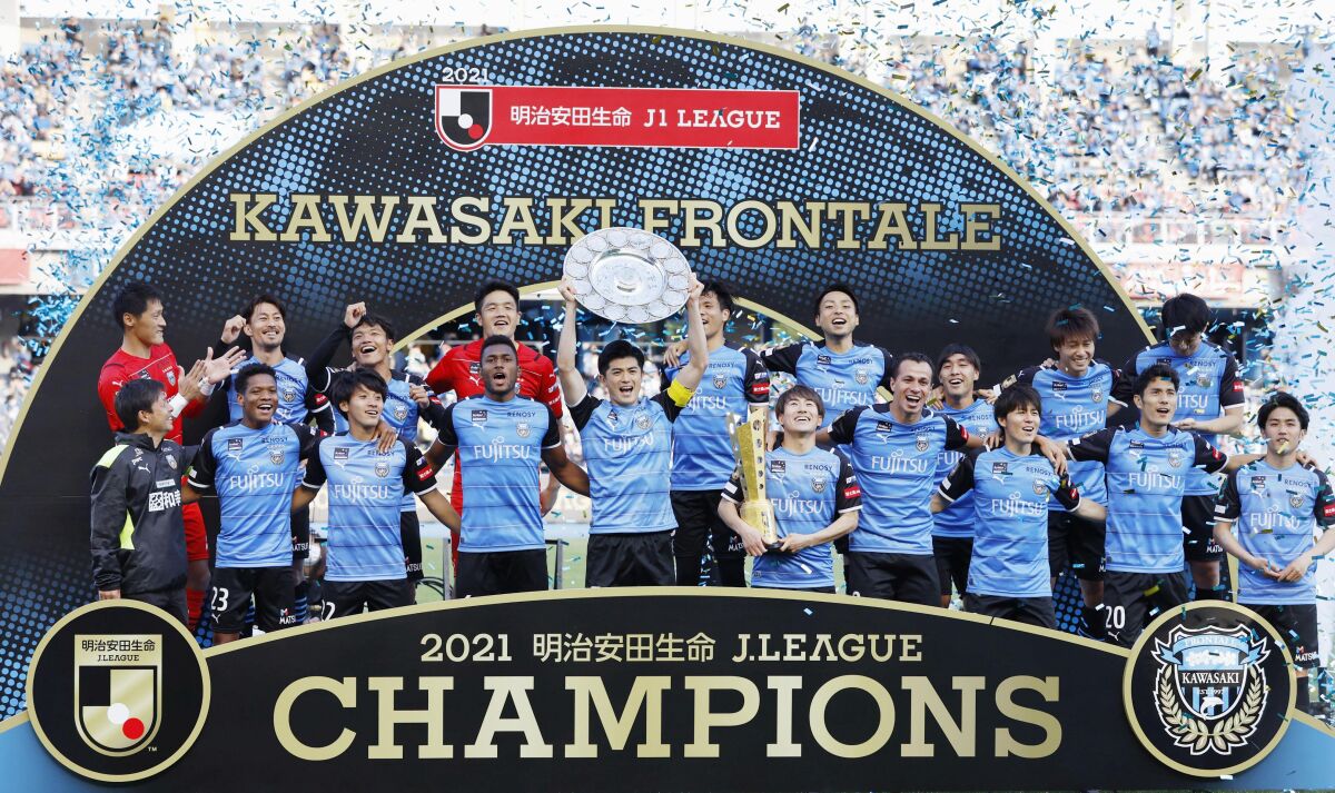Kawasaki Frontale players celebrate with the trophy after winning J-League title, drawing 1-1 with the Urawa Reds in Kawasaki, near Tokyo, Wednesday, Nov. 3, 2021. (Kyodo News via AP)