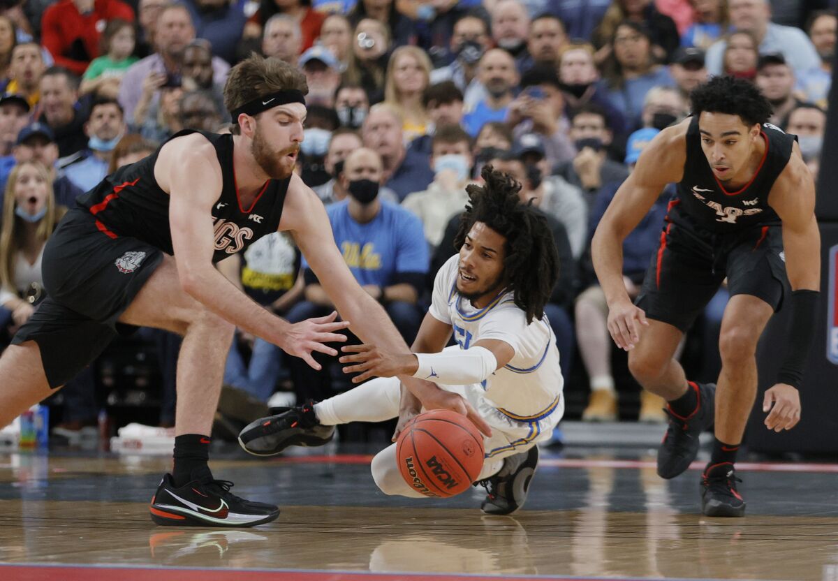 Tyger Campbell falls to the floor while losing the ball between Drew Timme and Andrew Nembhard.