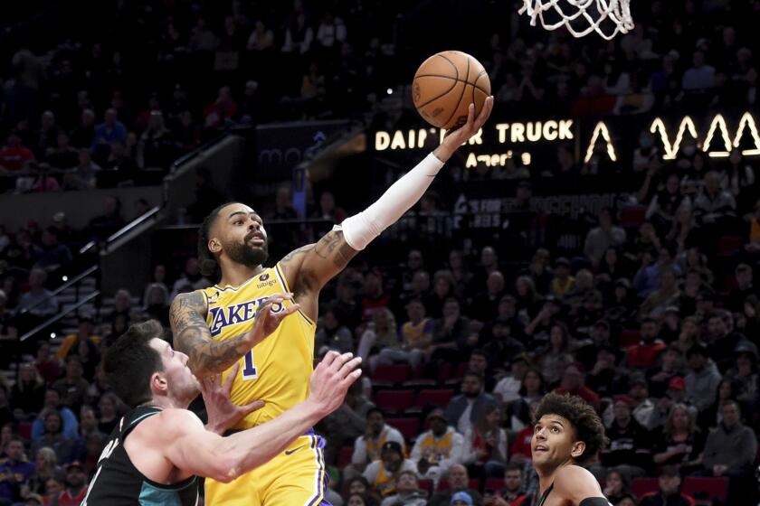 Los Angeles Lakers guard D'Angelo Russell, center, drives to the basket against Portland Trail Blazers forward Drew Eubanks, left, as guard Matisse Thybulle, right, looks on during the second half of an NBA basketball game in Portland, Ore., Monday, Feb. 13, 2023. (AP Photo/Steve Dykes)