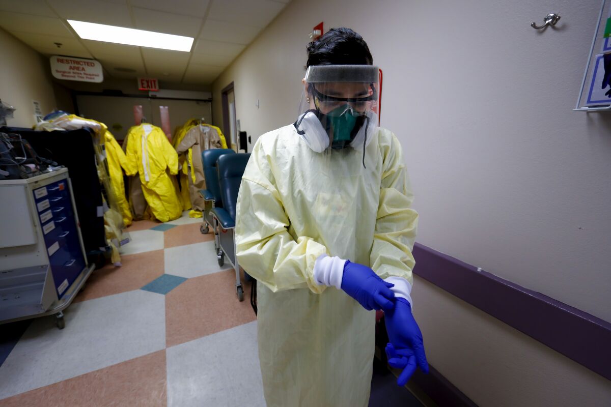 Lizabeth Velasquez adjusts her PPE while working in the COVID section of the hospital at El Centro Regional Medical Center.