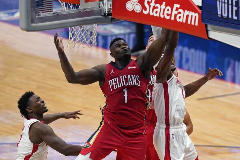 El alero de los Pelicans de Nueva Orléans Zion Williamson pelea por el balón con Danuel House y Jae'Sean Tate de los Rockets de Houston en el encuentro del martes 9 de febrero del 2021. (AP Photo/Gerald Herbert)