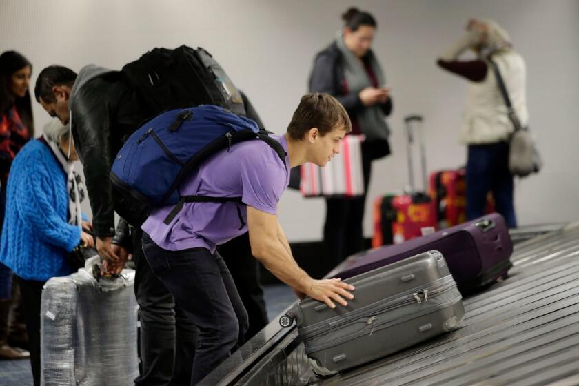 A traveler gathers his luggage at the San Francisco International Airport Sunday, Nov. 22, 2015, in San Francisco.(AP Photo/Marcio Jose Sanchez)
