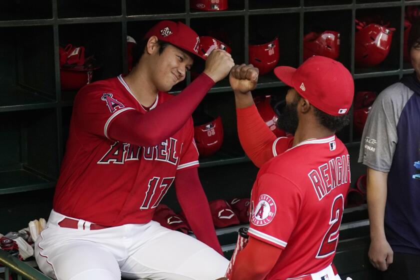 Los Angeles Angels designated hitter Shohei Ohtani, left, is greeted by Luis Rengifo prior to a baseball game against the Seattle Mariners Saturday, Sept. 25, 2021, in Anaheim, Calif. (AP Photo/Mark J. Terrill)