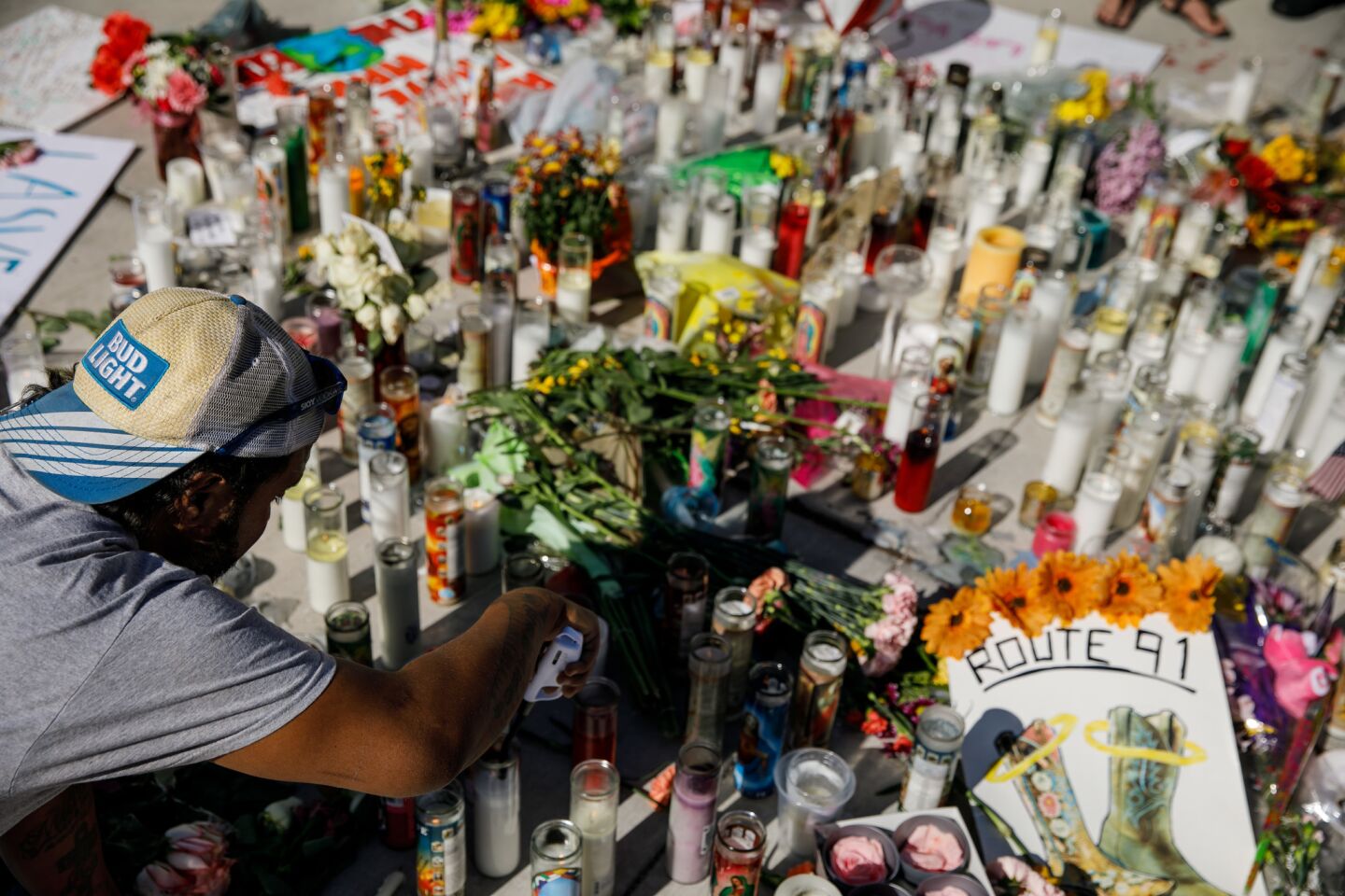 Matthew Edwards lights candles at a makeshift memorial at Sahara Avenue and Las Vegas Boulevard in Las Vegas for the victims of the mass shooting.