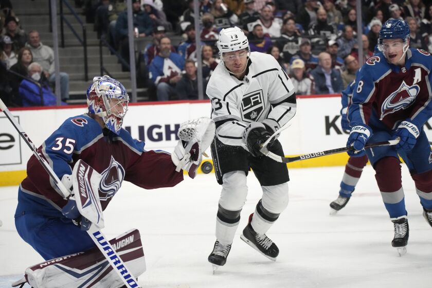 Colorado Avalanche goaltender Darcy Kuemper, left, makes a save against Los Angeles Kings center Gabriel Vilardi, center, who had slipped past Colorado defenseman Cale Makar during the second period of an NHL hockey game Wednesday, April 13, 2022, in Denver. (AP Photo/David Zalubowski)