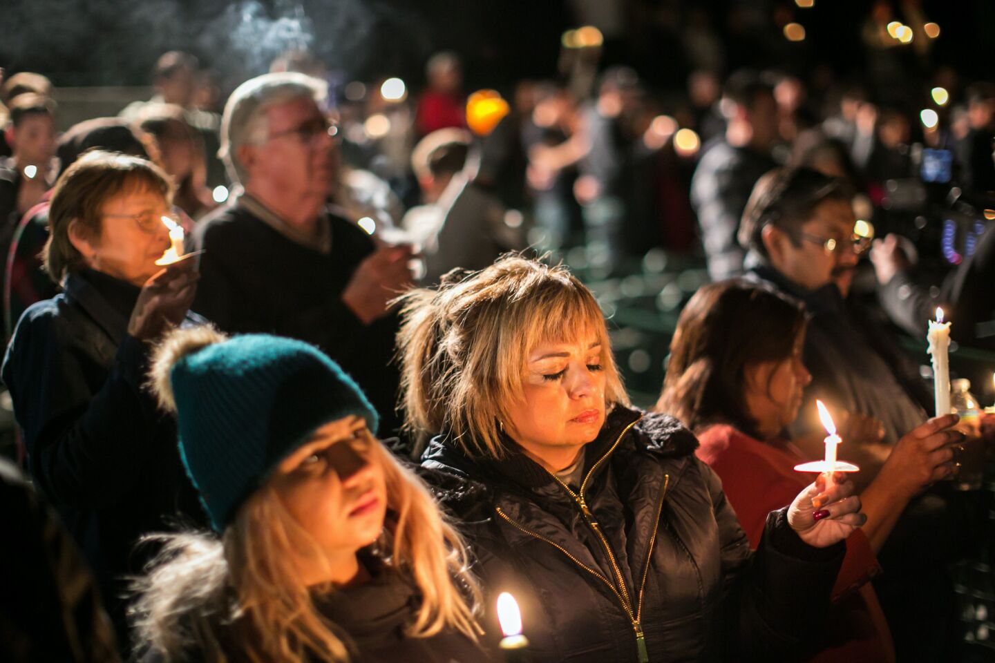 Josie Ramirez-Herndon, center, and her daughter, Chelsie Ramirez, bottom left, join other community members as they pray during a candlelight vigil.
