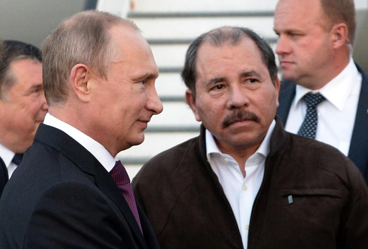 FILE - Nicaragua's President Daniel Ortega, right, and Russian President Vladimir Putin, left, attend a welcome ceremony at an airport in Managua, Nicaragua, July 11, 2014. The U.S. imposed sanctions Friday on Nicaragua's state-owned gold mining company, Empresa Nicaraguense de Minas, also known as ENIMINAS, along with the president of the firm's board of directors. The sanctions are imposed, in part, because the country's leaders are “deepening their relationship with Russia as it wages war against Ukraine, while using gold revenue to continue to oppress the people of Nicaragua,” according to the Treasury Department. (AP Photo/RIA-Novosti, Alexei Nikolsky, Presidential Press Service, File)