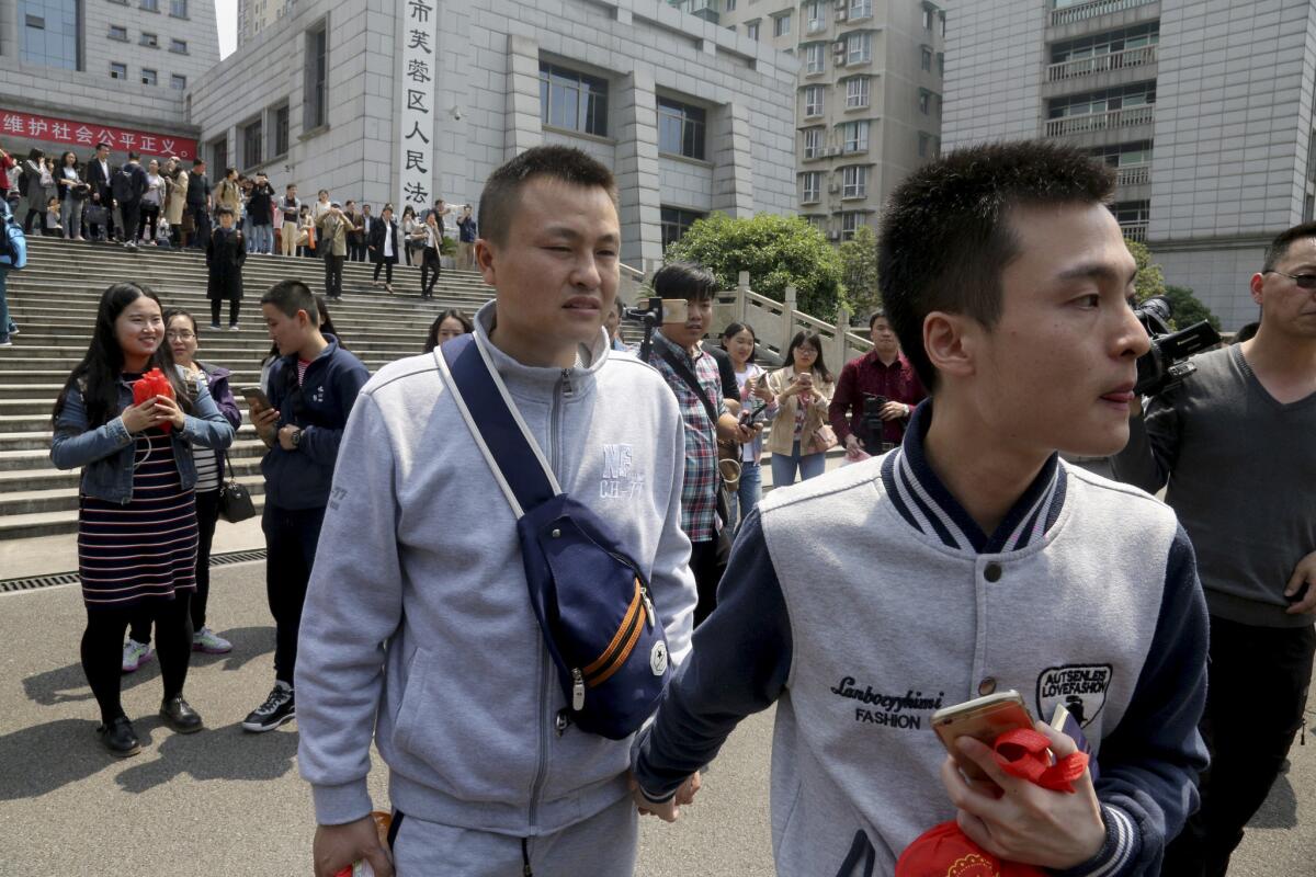 Sun Wenlin, right, and his partner, Hu Mingliang, leave the court April 13 after a judge ruled against them in China's first same-sex marriage case.