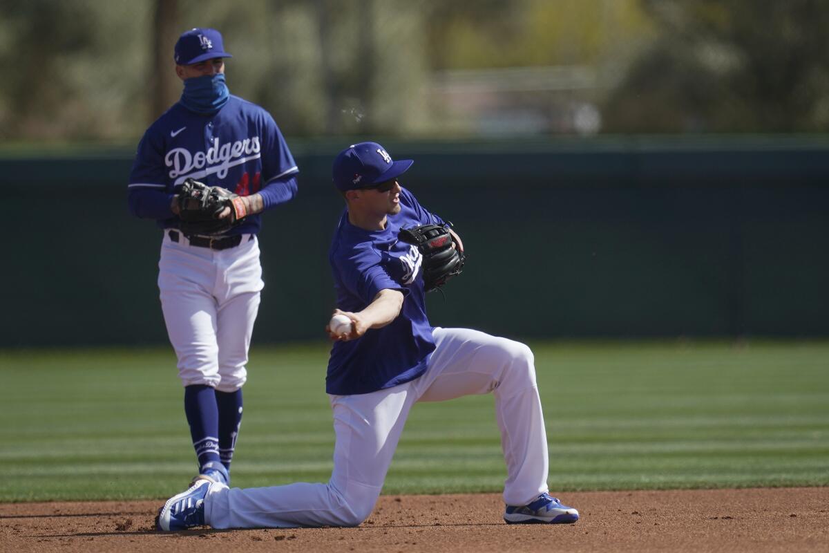 Dodgers shortstop Corey Seager throws to second base as Dodgers infielder Omar Estevez looks on.