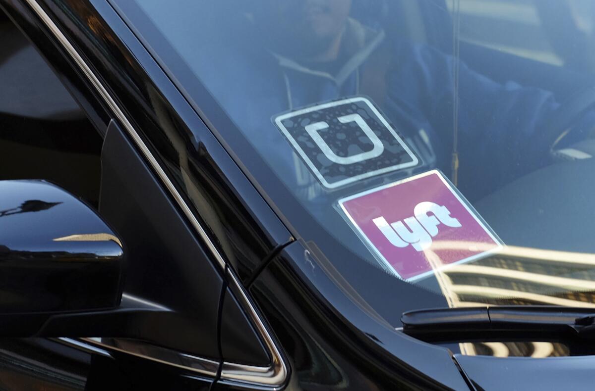 A car displays Lyft and Uber stickers on its front windshield.