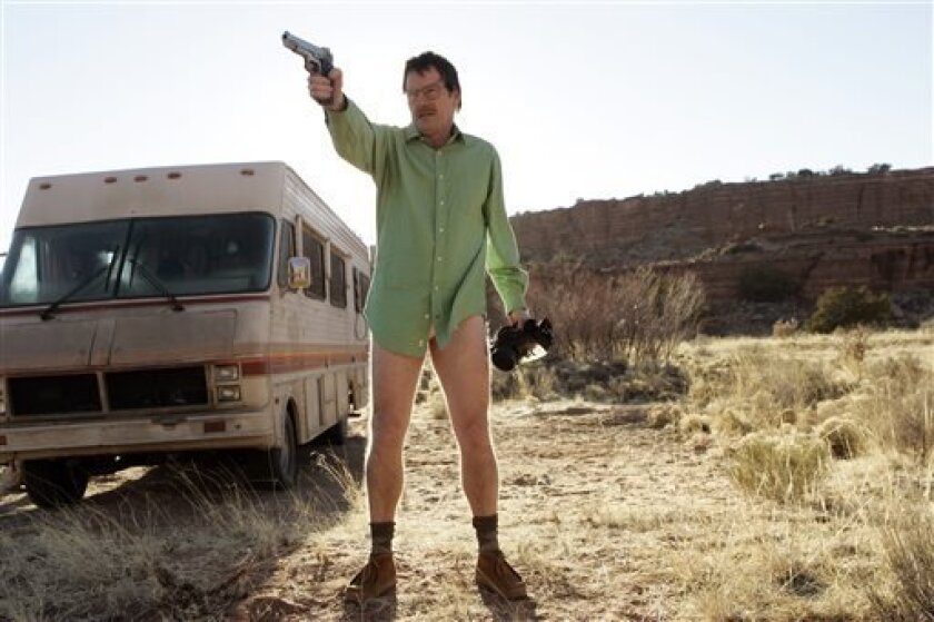 This image released by AMC shows Walter White, played by Bryan Cranston, next to the Winnebago he uses as a mobile meth lab.